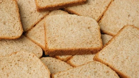 Close-up of a stack of crispy whole wheat toast bread slices rotating slowly. Stock Footage 337561553