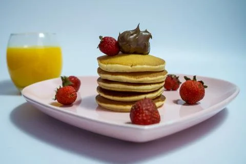 Close-up of stack of delicious fluffy pancakes with fresh strawberries and su Stock Photos