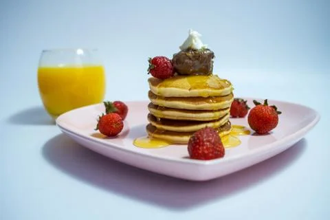 Close-up of stack of delicious fluffy pancakes with fresh strawberries and su Stock Photos