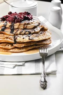 Close-up a stack of delicious hot pancakes with chocolate and raspberry jam.  Stock Photos