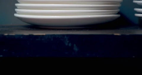Close-up of a stack of empty white plates in the kitchen. Male hands taking Stock Footage 150627903