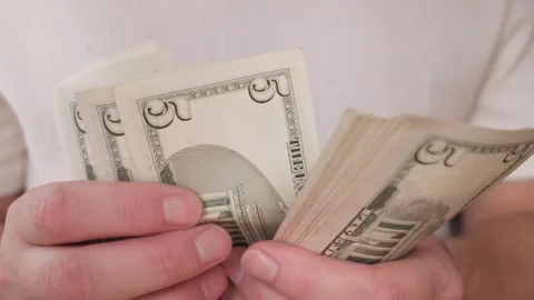 A close stack of five-dollar bills in the hands Stock Footage 287547984