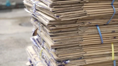 Close-up of a stack of flattened used cardboard boxes, neatly bundled with Stock Footage 310677318