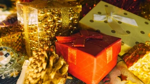 Close up, Stack of gift boxes under Christmas tree with lights flashing in Stock Footage 121715680