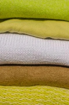 Close up the stack of green and beige sweaters Stock Photos