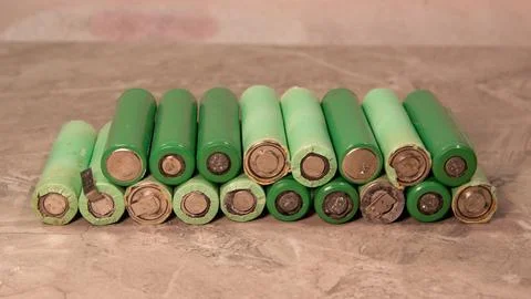 Close-up of a stack of green lithium-ion batteries arranged on a surface Stock Photos