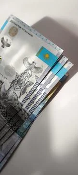Close-up stack of Kazakhstan tenge banknotes on white surface. 스톡 사진