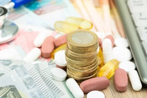 Close up of a stack of money with capsules and a stethoscope in the backgroun Foto stock