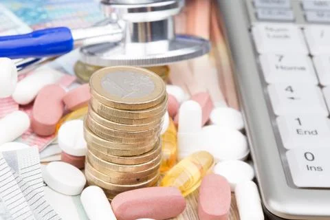 Close up of a stack of money with capsules, a stethoscope and a calculator Stock Photos