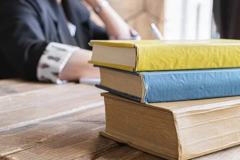 Close-up of a stack of old shabby books on a wooden desk Stock Photos