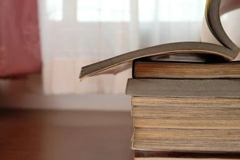 Close up of stack or pile of old book that place on a table near to the windo Stock Photos