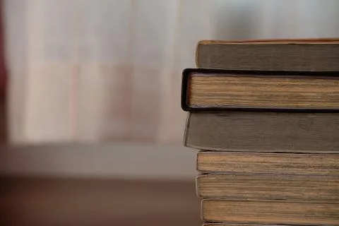 Close up of stack or pile of old book that place on a table near to the windo Stock Photos