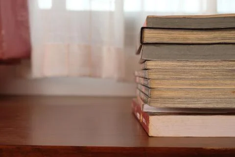 Close up of stack or pile of old book that place on a table near to the windo Stock Photos