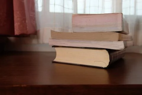 Close up of stack or pile of old book that place on a table near to the windo Stock Photos