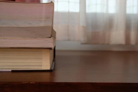 Close up of stack or pile of old book that place on a table near to the windo Stock Photos
