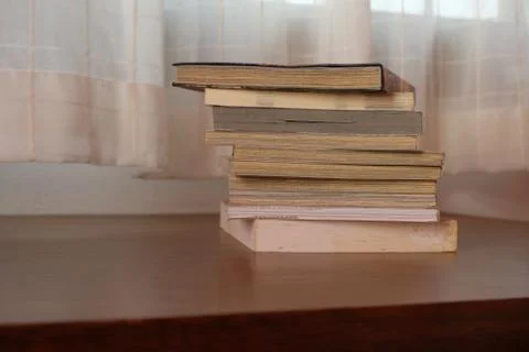 Close up of stack or pile of old book that place on a table near to the windo Stock Photos