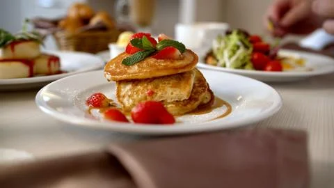 Close up of a stack of pancakes with fresh strawberries, mint, and syrup fo.. Stock Photos