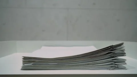 Close up stack of paper documents disappearing step by step. Stop motion Stock Footage 320348070