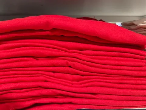 Close up of a stack of red clothes on the shelf in the store Stock Photos