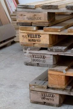 Close-up stack of shipping pallets with Velux inscription lying on the cement Stock Photos