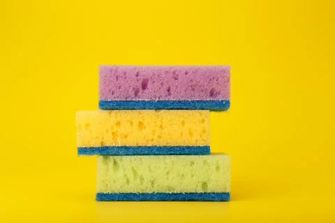 Close up of stack of three multicolored cleaning or kitchen sponges on bright Stock Photos