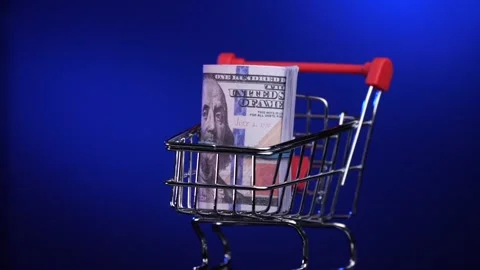 Close-up of a stack of US dollar bills in a rotating shopping cart, trolley Stock Footage 265033424