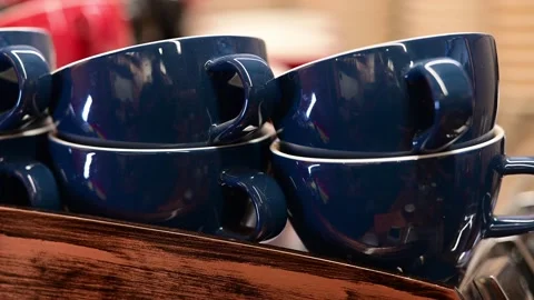 Close-up of stacked blue coffee cups on a wooden shelf Video stock 324612533