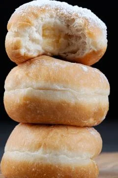 Close up of stacked donuts with the top one sliced open showing rich cream Stock Photos