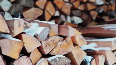 Close-up of stacked firewood logs with fresh snow, winter fuel stock for rural Stock Footage 327531401