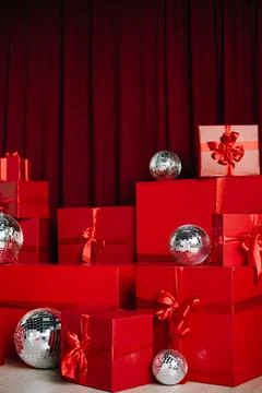 Close-up of stacked red wrapped gift boxes and silver disco balls. Stock Photos