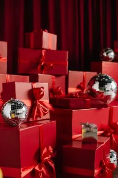 Close-up of stacked red wrapped gift boxes and silver disco balls. Stock Photos