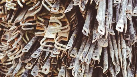 Close up of stacked rusty metal construction rebar hooks and steel profiles. Stock Photos