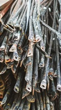 Close up of stacked rusty metal construction rebar hooks and steel profiles. Stock Photos