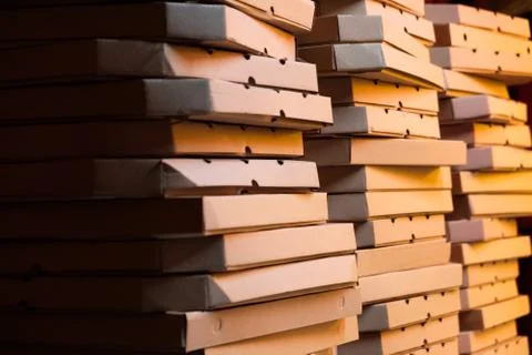 Close up of stacks with pizza boxes in low neon yellow light Stock-Fotos