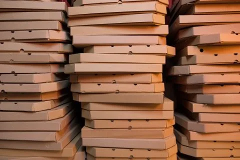 Close up of stacks with pizza boxes in low neon yellow light Stock Photos