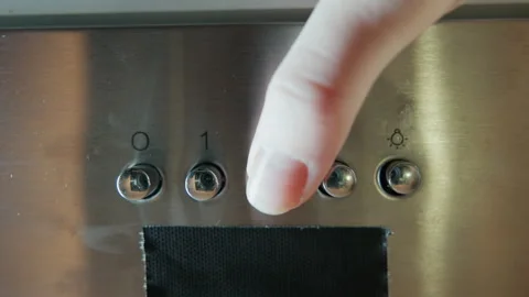 Close-up stainless steel control panel with finger pressing numbered button Stock Footage 345654388