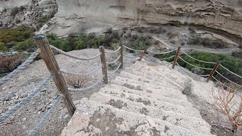 Close up of staircase descending to the bottom of a deep ravine in the desert Stock Footage 196739385
