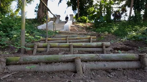 Close up of stairs made from bamboo from below, people at top of cement stairs Vídeos de archivo 77498058