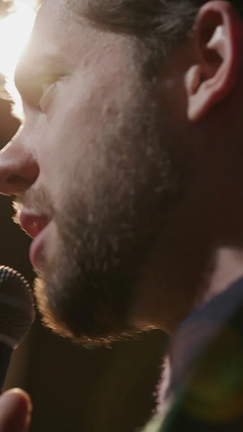 Close Up of Stand Up Comic Speaking into Microphone under Stage Lighting Stock Footage 333228403