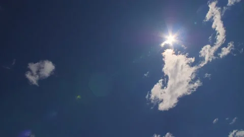 Close up of star shaped sun with blue sunny sky background and white clouds. Stock Footage 156940382
