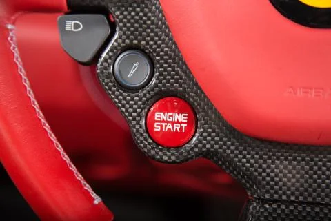 Close up of start engine button on red leather car steering wheel Stock Photos