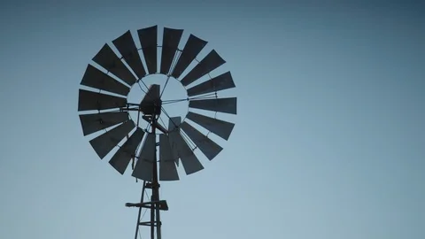 Close up of a static old windmill against a blue cloudless sky Stock Footage