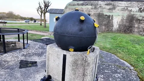 Close-up static shot of a historic black naval mine displayed on a concrete pede Vídeos de archivo 332860941