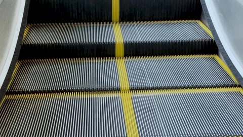 Close up static shot of moving escalator steps with yellow safety lines at .. Stock-Footage 337583610