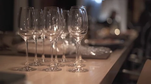 Close-up static shot of some empty clear wine glasses on a table ready for Stock Footage 108175315