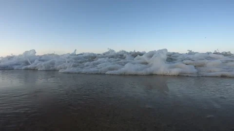 Close-up static shot of waves breaking on beach shore against the camera Vidéo 304280240