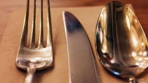 Close up static view of shiny stainless steel fork knife and spoon arranged.. Vídeos de archivo 339642492