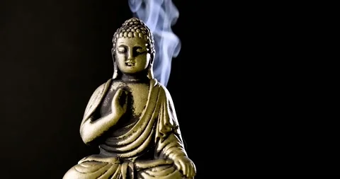 Close up statuette of Buddha with smoke of incense on black background.  Stock Footage 219683841