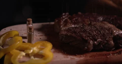 Close-up steak on a black background with spices and vegetables Stock Footage 130360805