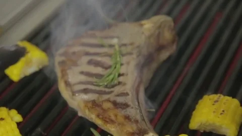 Close-up of a steak cooked on a grill with corn, in a restaurant Stock Footage 82684431
